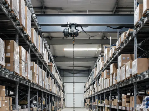 Narrow warehouse aisle under a runway